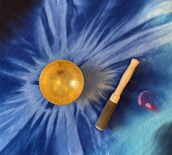 Singing bowl on a blue blanket.