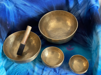 Four tibetan bowls on a azure blanket.